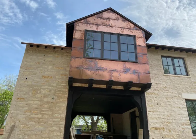 Copper metal panel facade on a stone building for Roof Repair in Gray