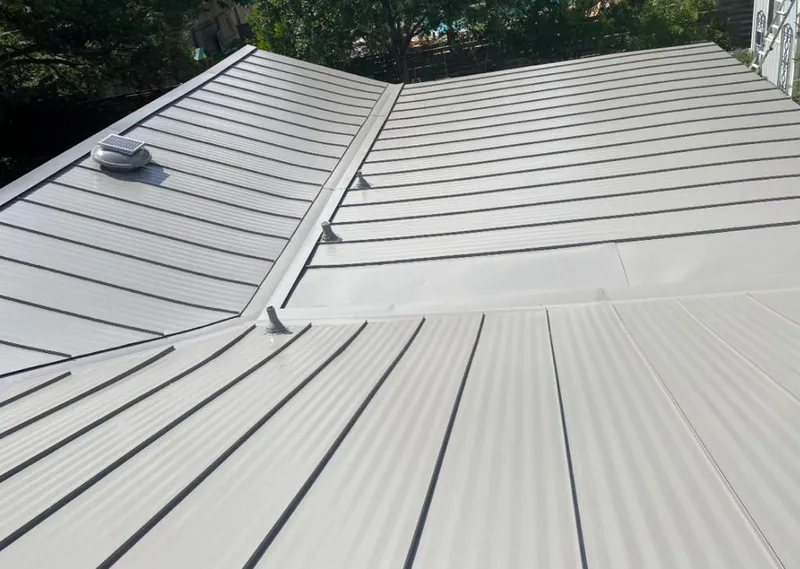 Solar attic fan installed on a metal roof for Roof Ventilation in Gray